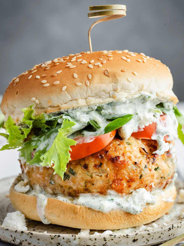 Juicy turkey burger topped with creamy tzatziki sauce on a burger bun.