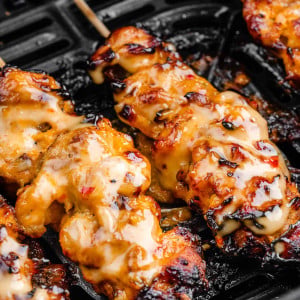 Chicken skewers cooked in an air fryer basket, golden and sizzling, with a glimpse of the crispy exterior.