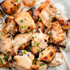 Crispy Air Fryer Cajun Bang Bang Salmon Bites served over steamed rice in a white bowl.