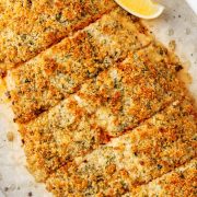 Image of a golden Baked Parmesan Crusted Salmon fillet with Mayo on a baking sheet.
