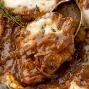 Close-up view of a French Onion Chicken fillet, showcasing the golden-brown crust, topped with rich, caramelized onions and melted cheese.