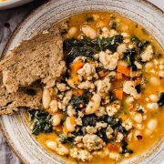 A bowl of hearty ground turkey soup with a side of fresh bread.