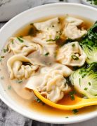 Image of Wonton Soup in a white bowl, showing delicate wontons submerged in a savory broth.