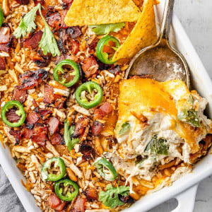 Image showing a freshly baked Jalapeรฑo Popper Chicken Casserole in a baking dish. The casserole is golden and bubbly on top, with visible pieces of jalapeรฑo, chicken, and melted cheese.
