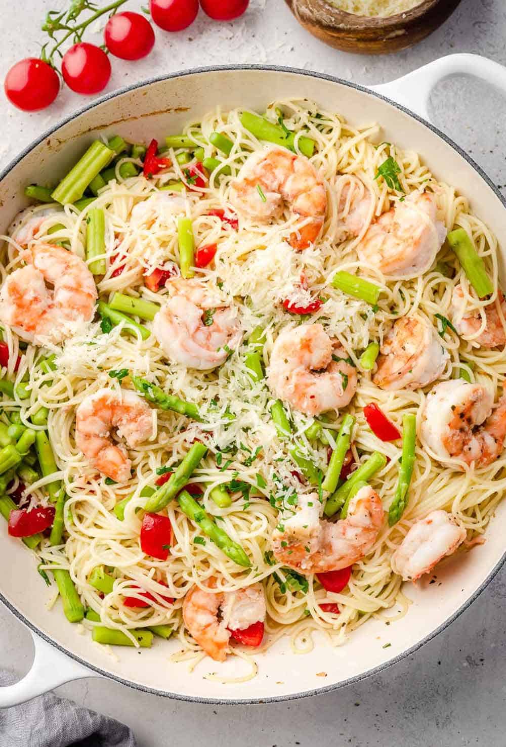 Olive Garden Shrimp Scampi pasta in a skillet, featuring plump shrimp nestled among angel hair pasta, all coated in a rich, garlicky butter and wine sauce.