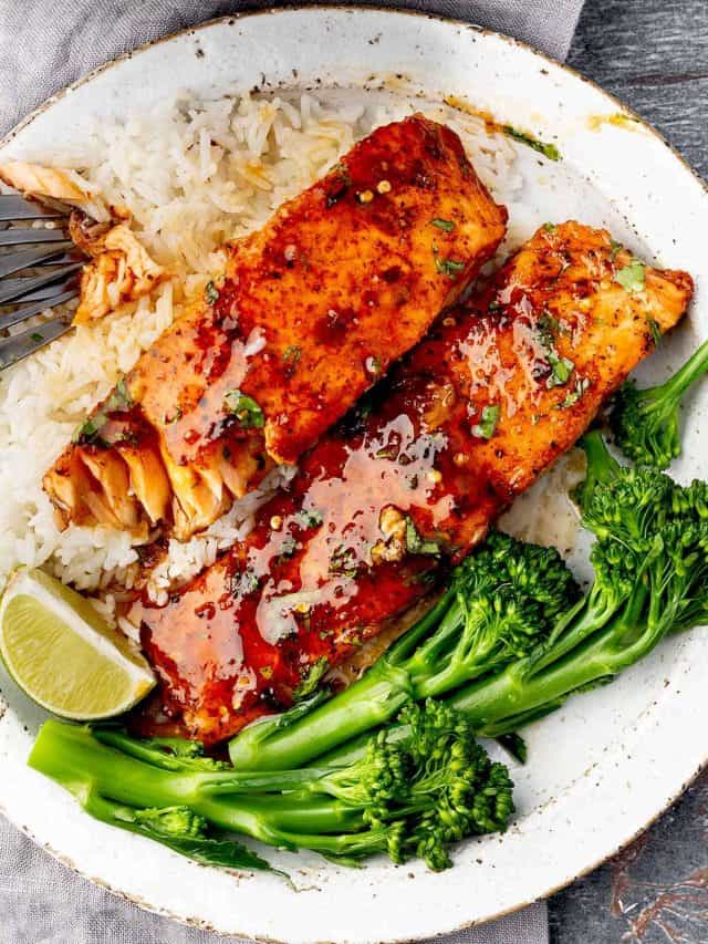 An overhead image showcasing a plate with delicious hot honey salmon fillets, accompanied by a side of fluffy rice and vibrant green broccolini.