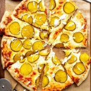 Overhead image of sliced Dill Pickle Pizza, showcasing the unique combination of pickles, cheese, and sauce on a crispy crust.