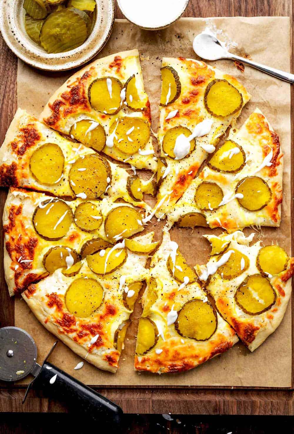 Overhead image of sliced Dill Pickle Pizza, showcasing the unique combination of pickles, cheese, and sauce on a crispy crust.