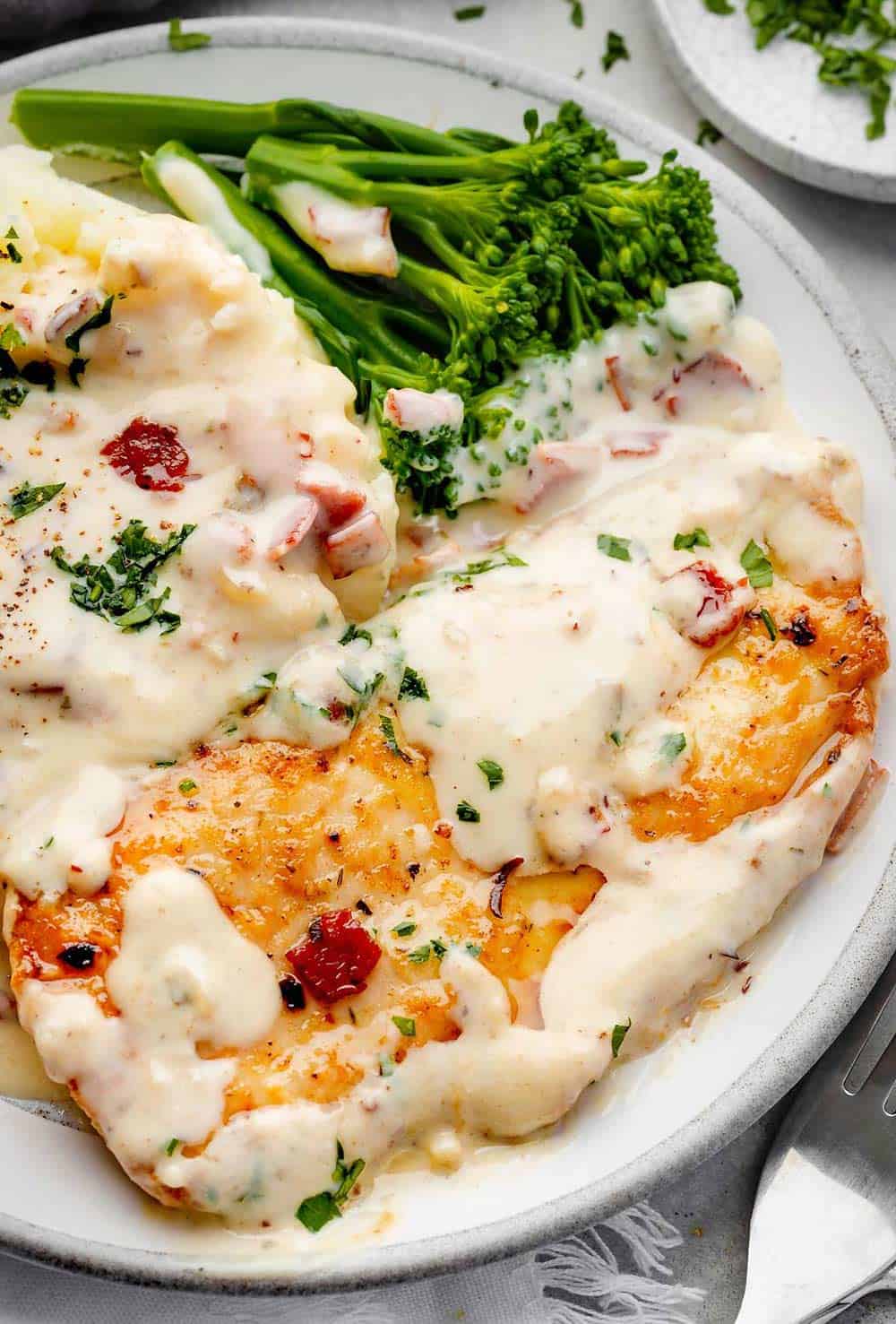 Delicious creamy ranch chicken fillet served atop creamy mashed potatoes with a side of vibrant broccolini.