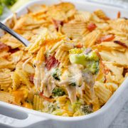 Holding a spoonful of Chicken Bacon Ranch Casserole, freshly scooped from the dish.