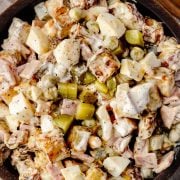 Dill Pickle Potato Salad in a wooden bowl, featuring creamy potatoes, crunchy dill pickles, deli ham, peas and a zesty dressing.