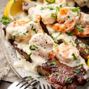 Close-up image of a juicy steak paired with creamy shrimp, served on a plate.