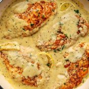 A delicious skillet filled with Garlic Parmesan Chicken. The chicken pieces are golden brown and coated in a rich, creamy garlic parmesan sauce, garnished with fresh parsley.