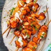 Buffalo Ranch Chicken Skewers served on a plate with a side of creamy ranch sauce.