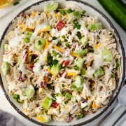 Overhead view of a bowl filled with Bacon Ranch Chicken Salad, featuring shredded chicken, sharp cheddar cheese, crispy bacon, diced cucumbers, and creamy homemade ranch dressing.