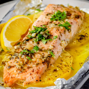 Baked Pineapple Salmon Foil Packet on a plate with pineapple slices.