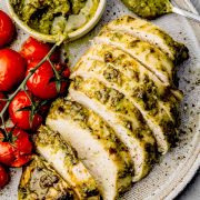 Overhead view of sliced pesto chicken on a plate.