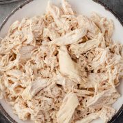 Close-up of a bowl filled with tender, shredded chicken breast, perfectly cooked and ready to use.
