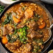 A rich and hearty beef barley soup served in a bowl, filled with tender beef, vegetables, and a savory broth.
