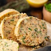 Sliced cowboy butter packed with herbs, garlic, and spices, ready to add flavor to steaks, seafood, or vegetables.