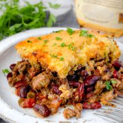 The image shows a hearty slice of Cowboy Cornbread Casserole on the white plate.