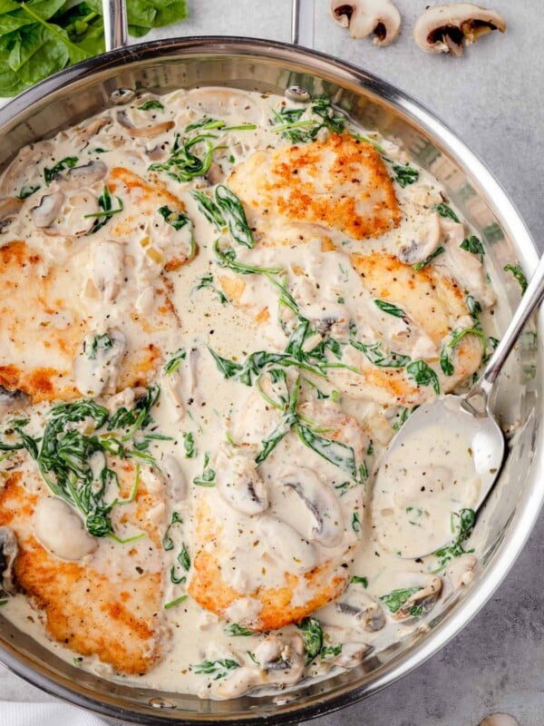 Creamy Chicken Florentine with mushrooms and spinach in garlic Parmesan sauce in a skillet.