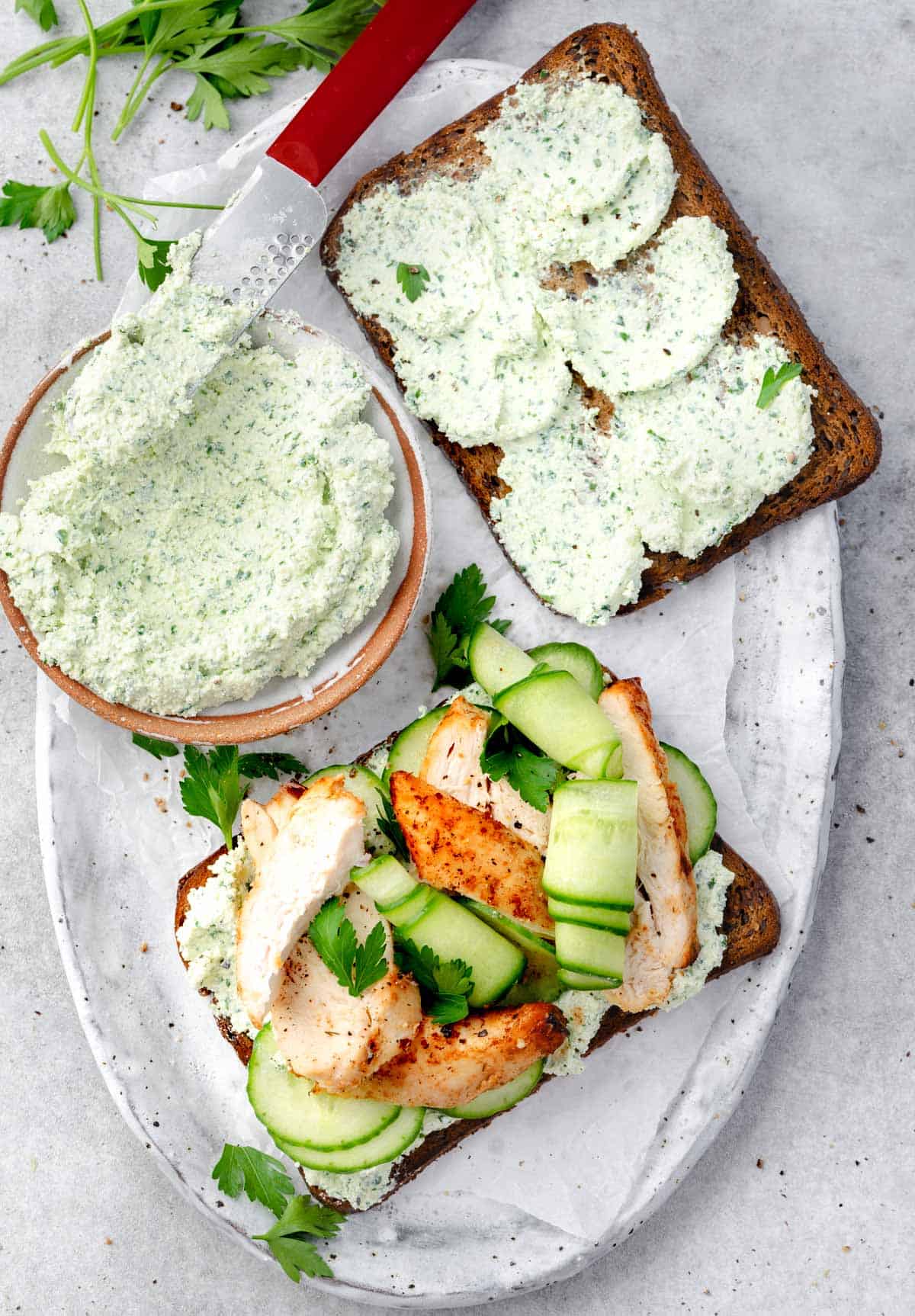 High-protein chicken cucumber cottage cheese toast with herbed cottage cheese spread, grilled chicken slices, fresh cucumber ribbons, and parsley on whole grain bread.