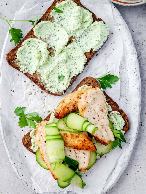 High-protein chicken cucumber cottage cheese toast with herbed cottage cheese spread, grilled chicken slices, fresh cucumber ribbons, and parsley on whole grain bread.