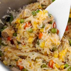 Instant Pot chicken and rice casserole with mixed vegetables, creamy rice, and tender chicken stirred inside the pressure cooker.