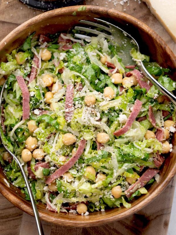 La Scala Chopped Salad with shredded romaine lettuce, chickpeas, salami, Parmesan cheese, and Italian dressing tossed together in a wooden serving bowl.