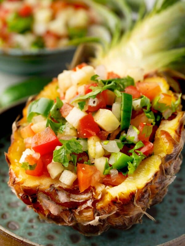 Pineapple Pico de Gallo served in a hollowed pineapple half, made with fresh pineapple, diced tomatoes, onion, jalapeรฑo, cilantro, and lime juice for a colorful tropical salsa.