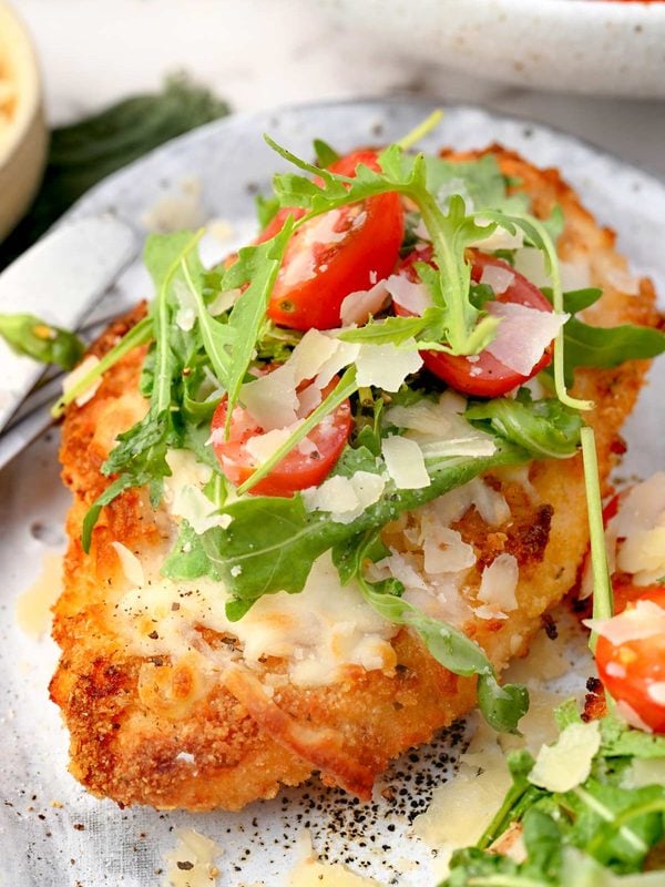 Crispy baked Chicken Milanese topped with melted mozzarella, arugula, cherry tomatoes, and shaved Parmesan.