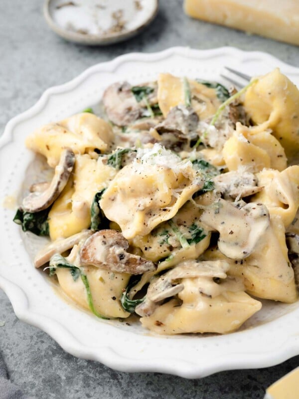 Creamy Boursin tortellini with mushrooms and spinach topped with freshly grated Parmesan cheese.