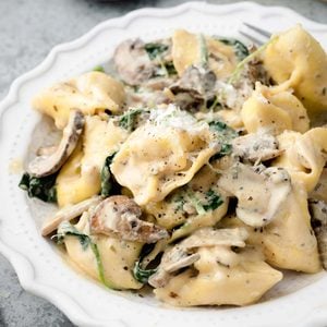Creamy Boursin tortellini with mushrooms and spinach topped with freshly grated Parmesan cheese.