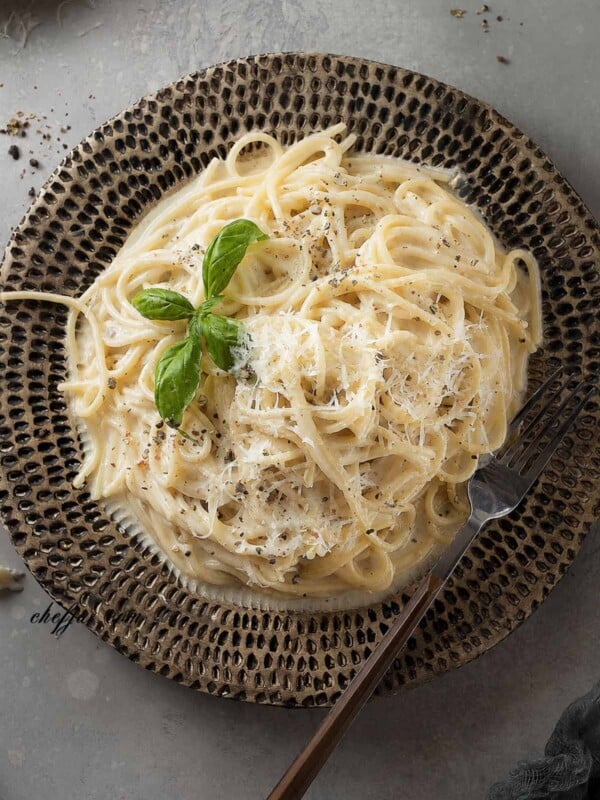 Creamy Cacio e Pepe spaghetti with Pecorino Romano and freshly ground black pepper on a plate.