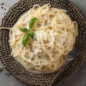 Creamy Cacio e Pepe spaghetti with Pecorino Romano and freshly ground black pepper on a plate.