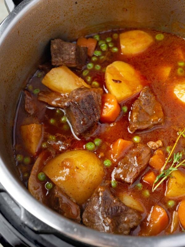 Instant Pot beef stew with tender chuck roast, Yukon Gold potatoes, carrots, and peas in a rich, savory broth.