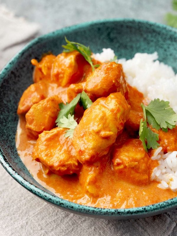 Instant Pot butter chicken with tender chicken breast in a creamy tomato sauce, served with white rice and fresh cilantro.