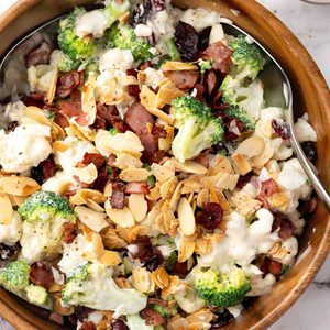 Broccoli cauliflower salad with creamy dressing, crispy turkey bacon, dried cranberries, toasted sliced almonds, and red onion.