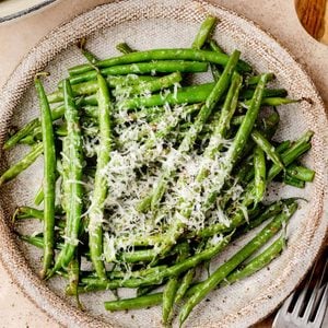 Cacio e pepe green beans topped with grated Pecorino Romano and freshly cracked black pepper.