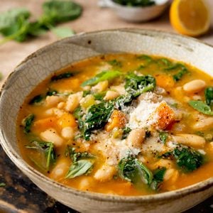 Italian spinach soup with white beans, carrots, Parmesan, and fresh spinach in a savory broth.
