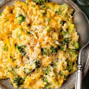 Creamy Broccoli Cheddar Orzo with tender broccoli florets, sharp cheddar cheese, and freshly grated Parmesan in a rustic ceramic bowl.