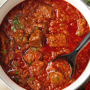 Hungarian goulash with tender beef chunks simmered in a rich paprika sauce in a Dutch oven.